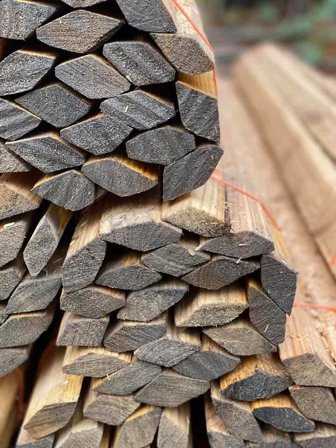 A bundle of hand cleft diamond staves made from chestnut wood, with visible natural grain and coloring.