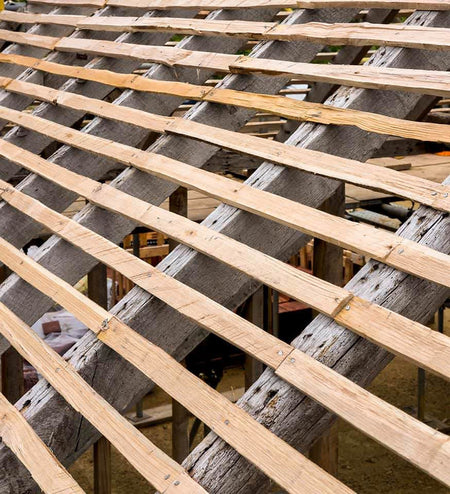 close up of 4ft hand cleft chestnut battens laying on roof joists