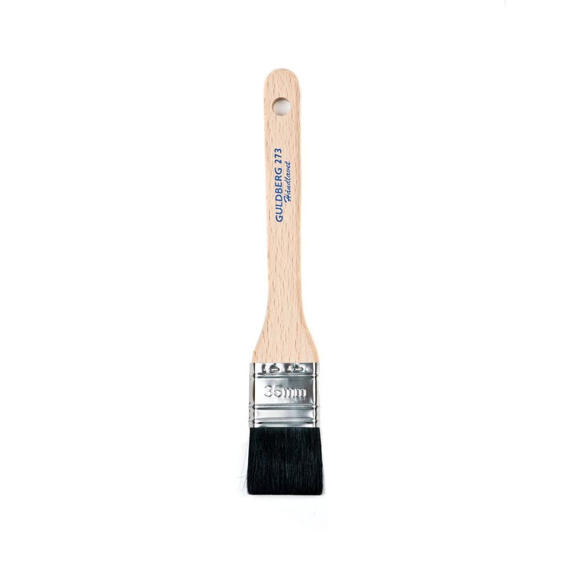 Paint brush with wooden handle and metal ferrule on a white background