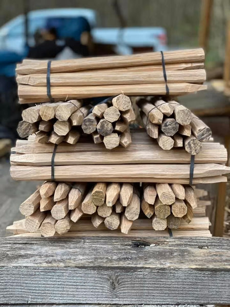 Stack of wooden oak pegs tied together on a wooden surface.