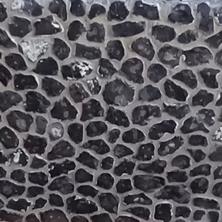 A close-up image of hand knapped chalk flint with a distinctive dark color and textured surface.
