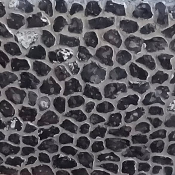 A close-up image of hand knapped chalk flint with a distinctive dark color and textured surface.