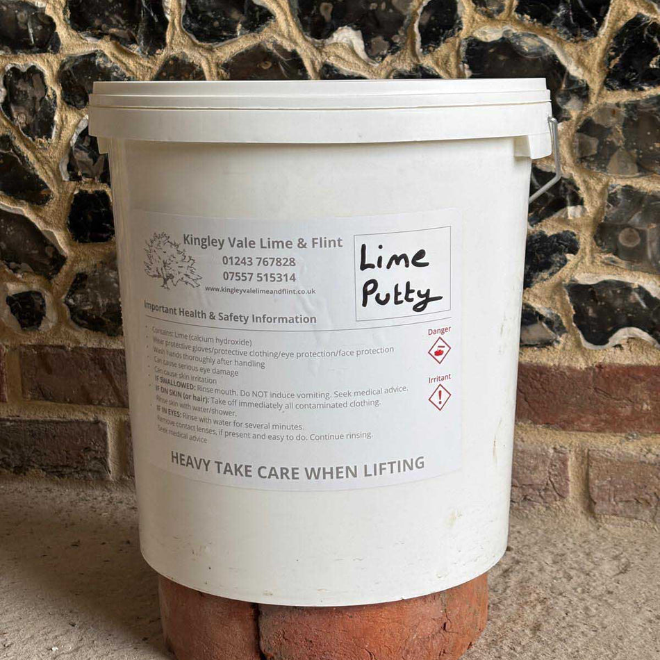 tub of lime putty with a flint wall background