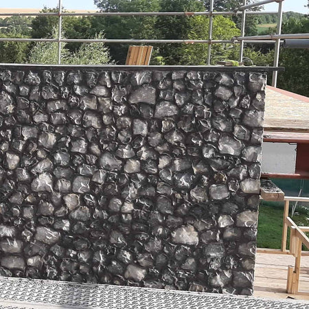picture of a grey flint wall with clean sharp corner detail. on a building site with scaffolding 