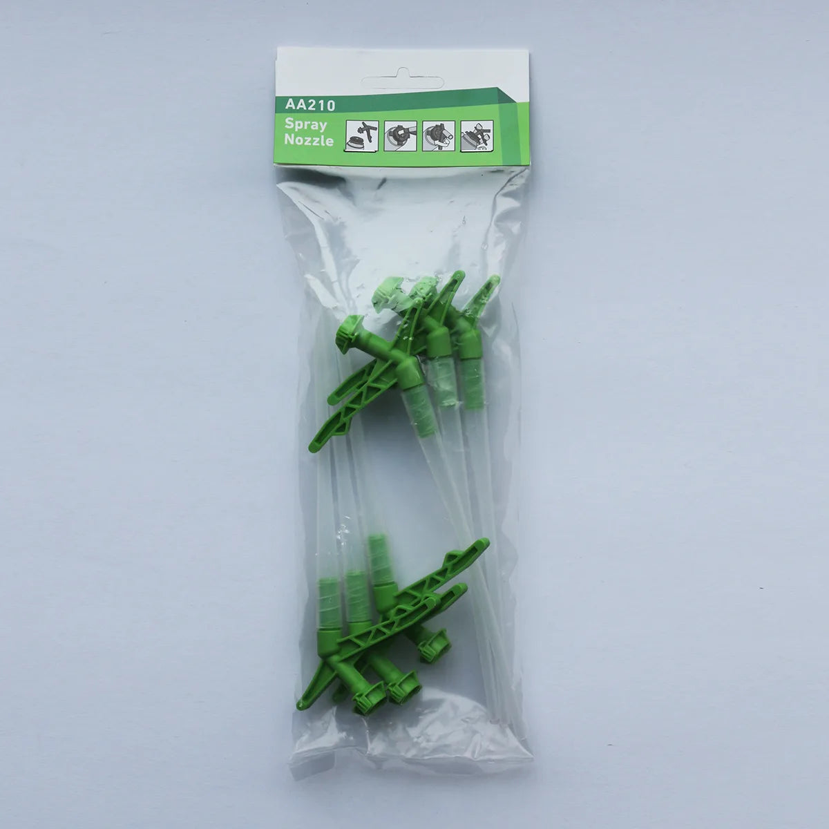 Packaged green spray nozzles with a clear plastic bag on a white background